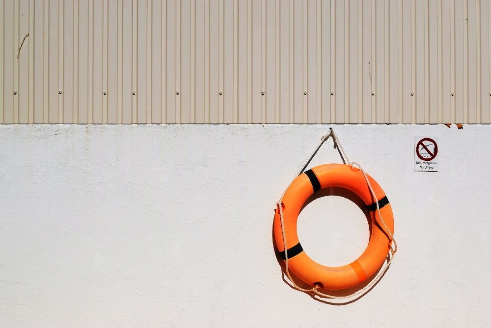Orange lifebuoy hanging on wall